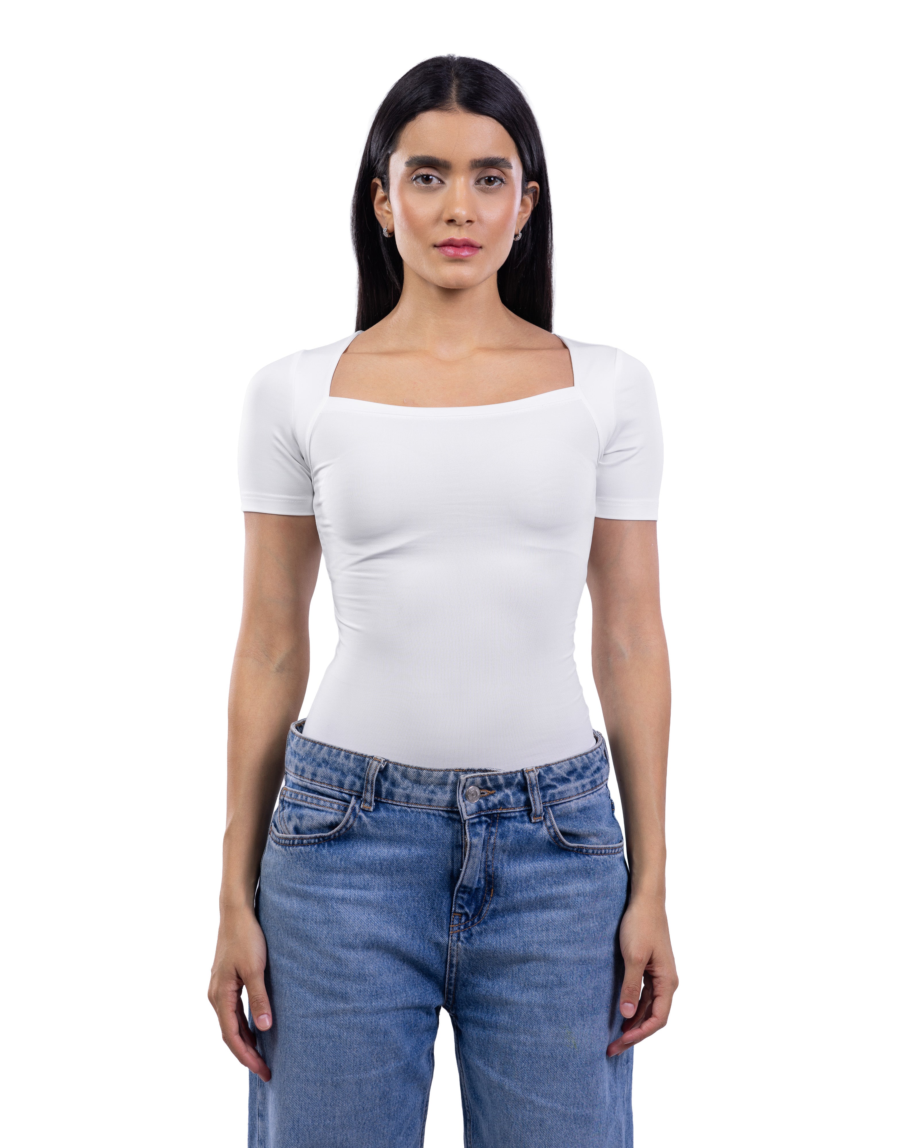 A woman modeling a fitted white short-sleeve top with a square neckline, paired with blue jeans, against a plain white background.