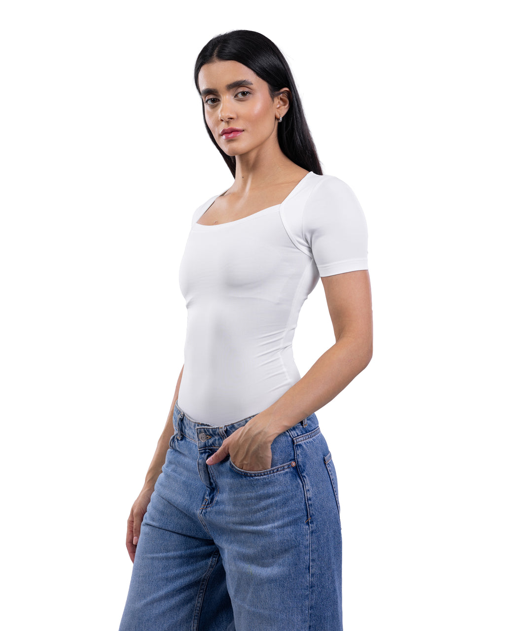 A woman modeling a fitted white short-sleeve scoop-neck top paired with blue jeans against a plain white background.