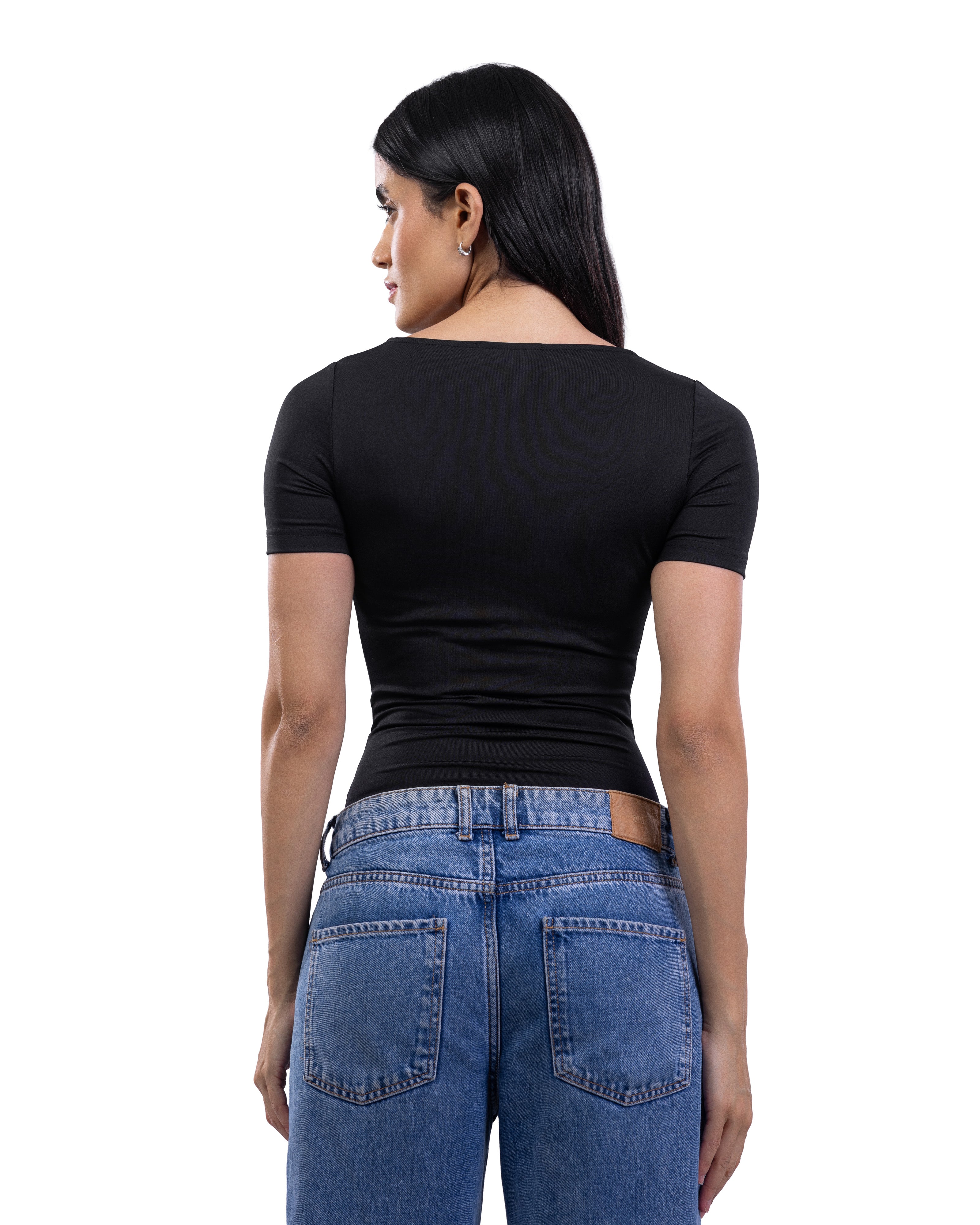 A woman shown from the back wearing a fitted black short-sleeve top and blue jeans against a plain white background.