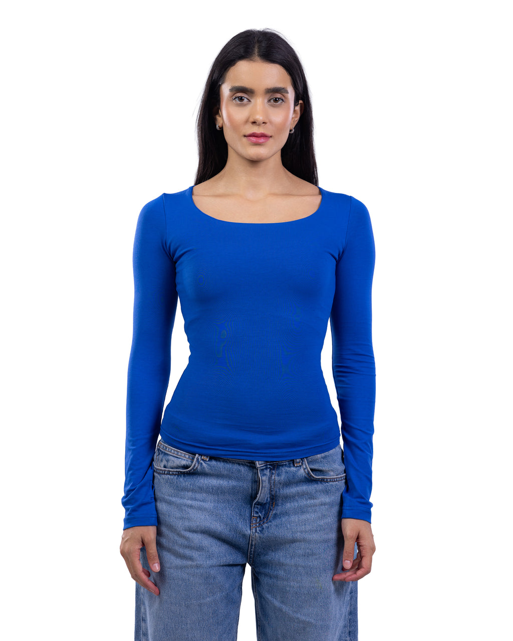 A woman modeling a bright royal blue long-sleeve scoop-neck top paired with blue jeans, shot against a solid white background.