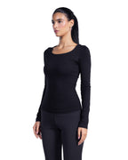 A woman modeling a black long-sleeve scoop-neck top and matching black leggings against a plain white background.