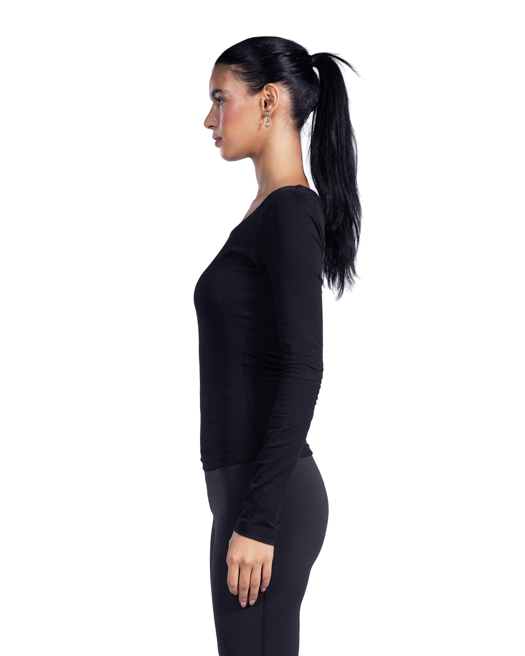 A woman in a side profile wearing a black long-sleeve athletic top and matching black leggings against a plain white background.