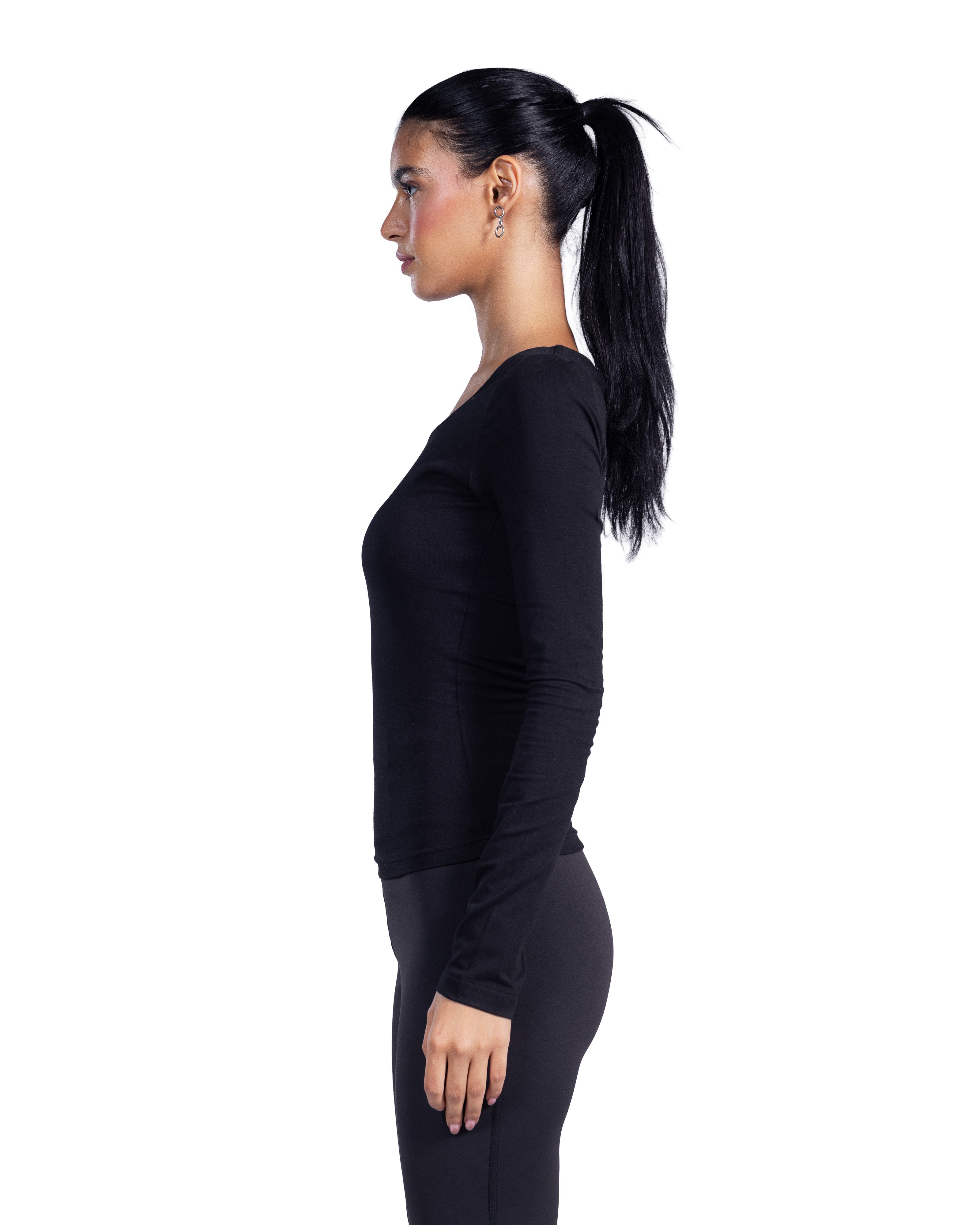 A woman in a side profile wearing a black long-sleeve athletic top and matching black leggings against a plain white background.