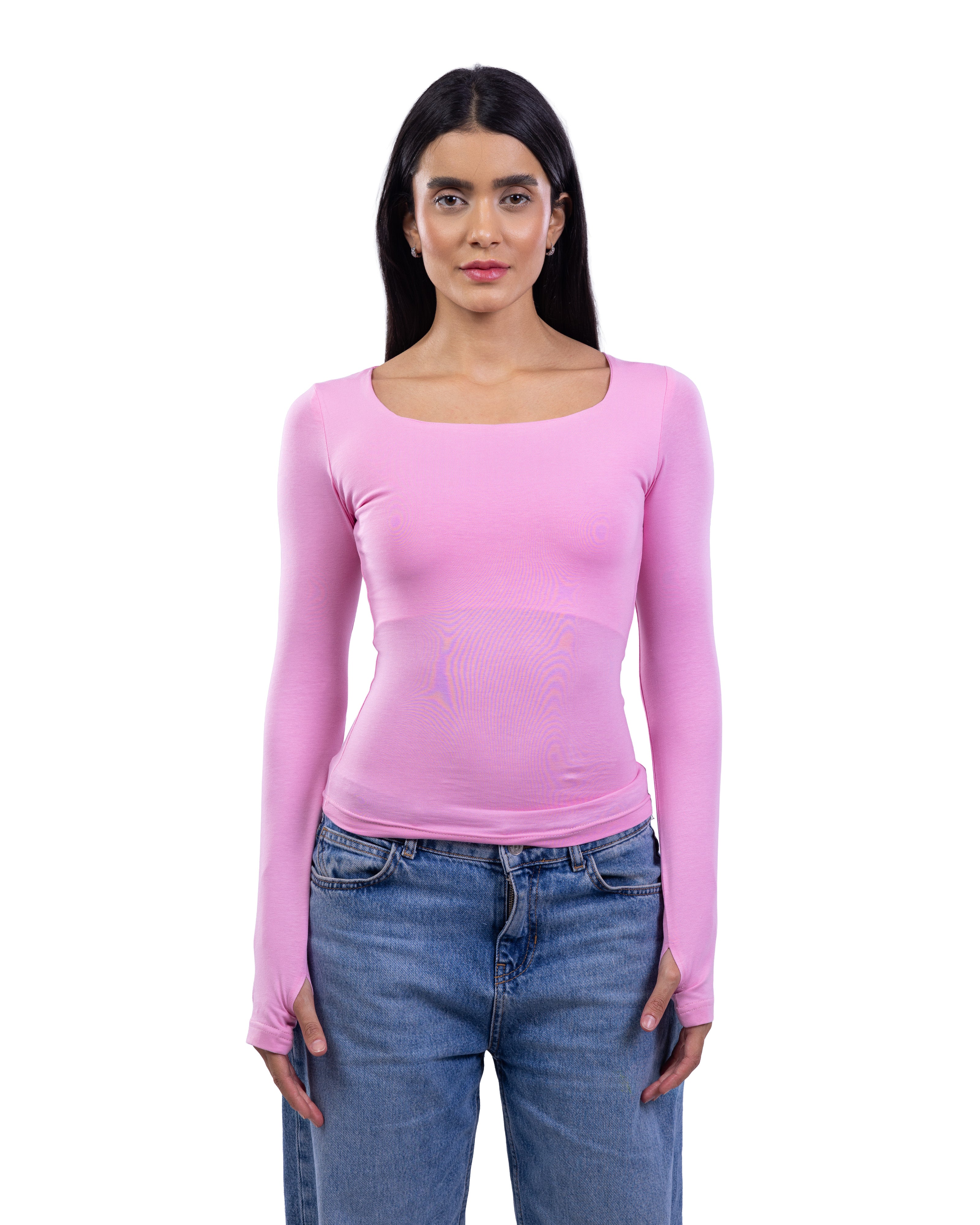 A woman modeling a light pink long-sleeve scoop-neck top with a textured mesh panel at the waist, paired with blue jeans, against a plain white background.