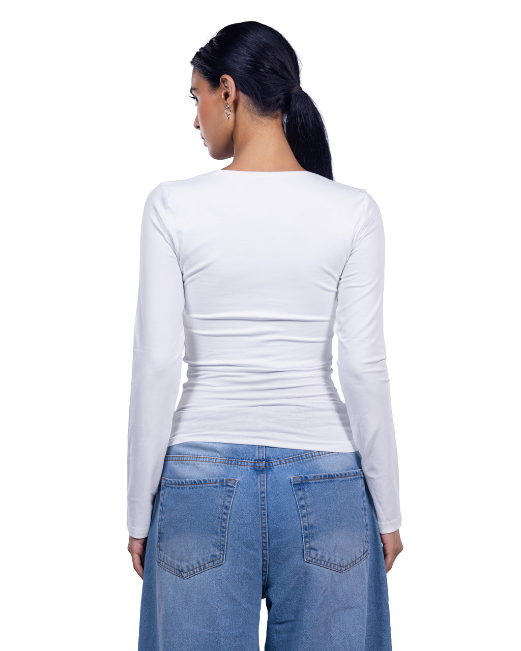 A woman shown from the back wearing a fitted white long-sleeve top and blue jeans against a plain white background.