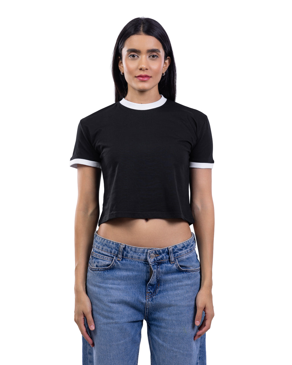 A woman modeling a black short-sleeve ringer crop top with white trim on the crew neck and sleeve cuffs, paired with blue jeans, against a plain white background.