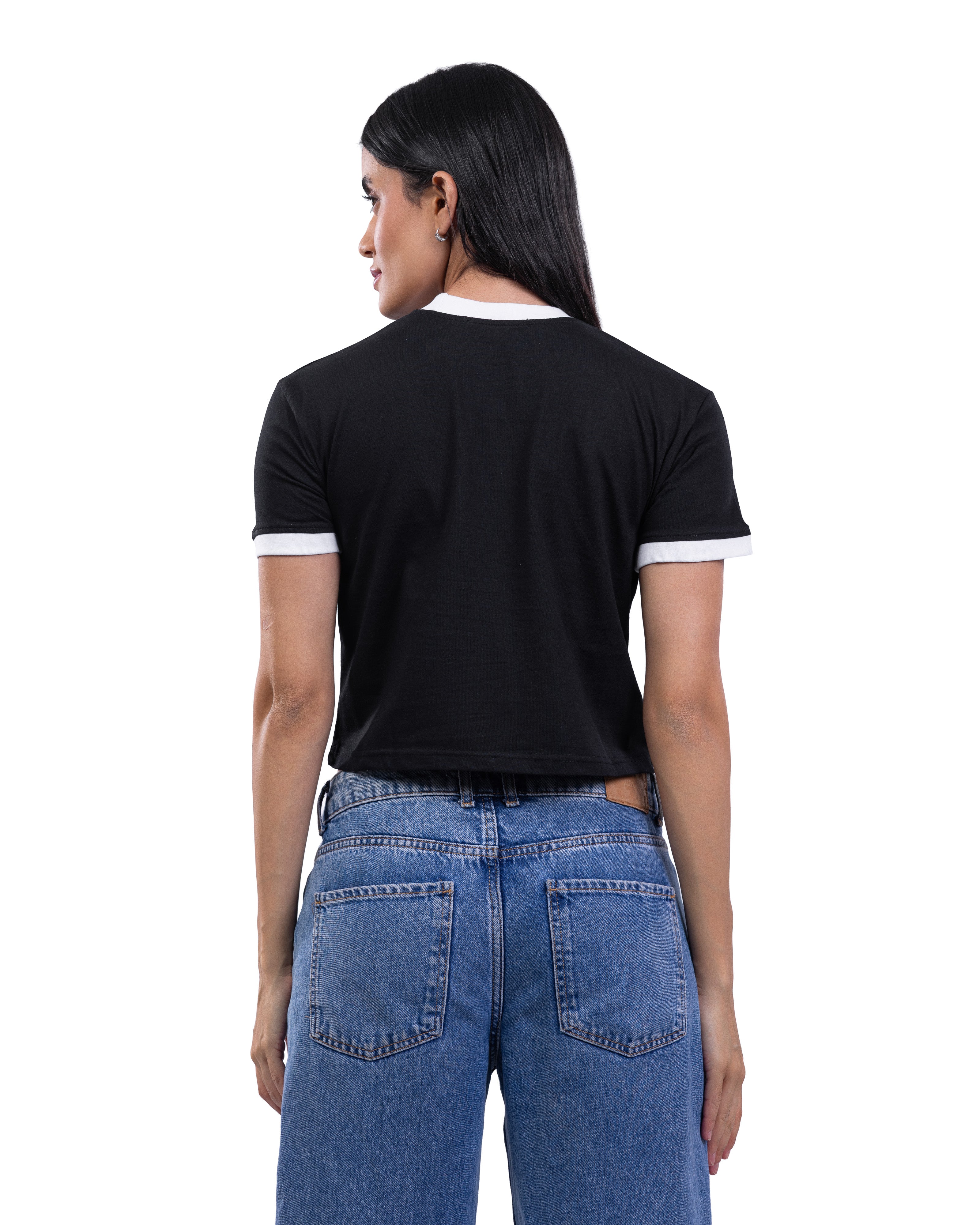 A woman shown from the back wearing a black short-sleeve ringer T-shirt with white trim on the collar and sleeve cuffs, paired with blue jeans, against a plain white background.