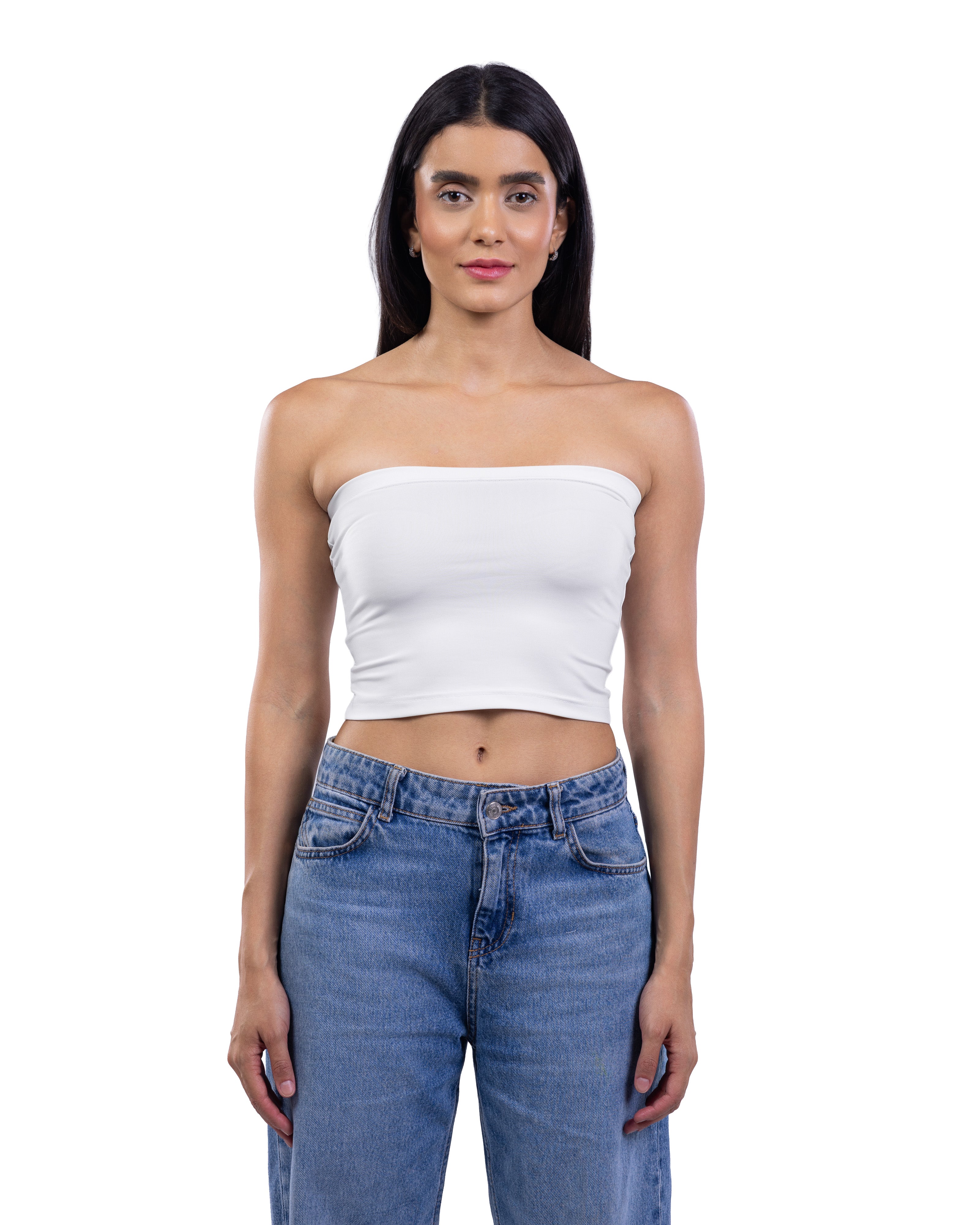 A woman modeling a white strapless bandeau crop top paired with blue jeans, shot against a solid white background.
