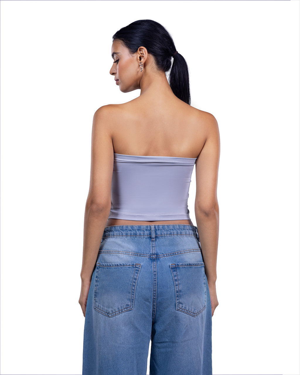 A woman shown from the back wearing a lavender strapless tube top and blue jeans against a plain white background.