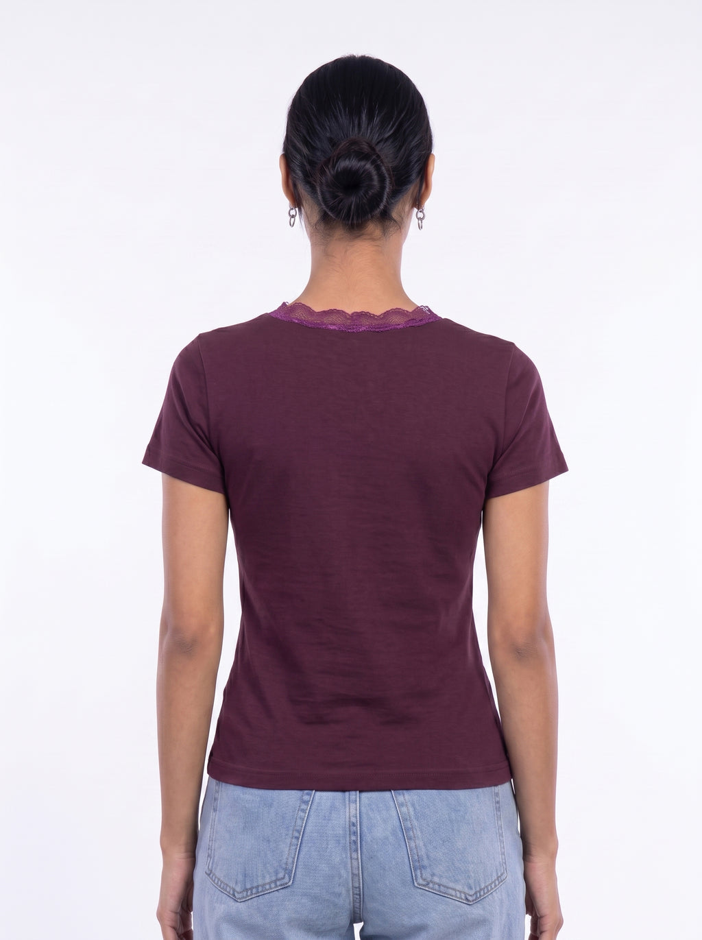 A woman viewed from the back wearing a short-sleeve maroon t-shirt with a scalloped lace trim at the neckline, paired with light blue jeans, against a plain white background.