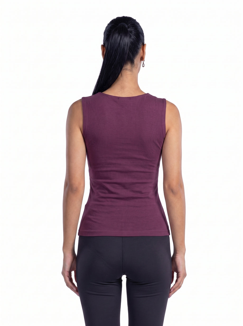 A woman viewed from the back wearing a sleeveless, fitted athletic top in a muted plum-purple color, paired with dark leggings, against a plain white background.