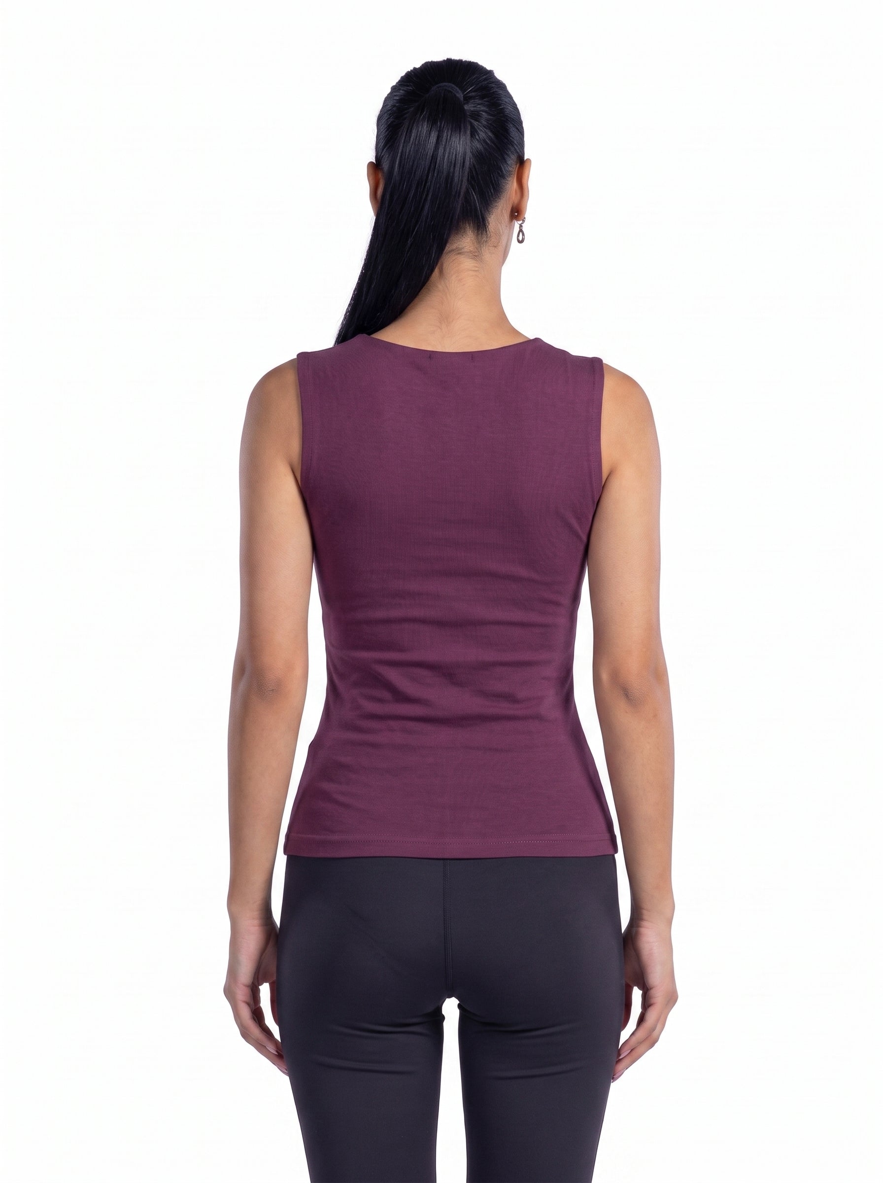A woman viewed from the back wearing a sleeveless, fitted athletic top in a muted plum-purple color, paired with dark leggings, against a plain white background.