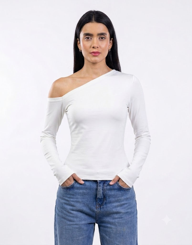A woman modeling a white long-sleeve asymmetrical one-shoulder top paired with blue jeans, set against a plain white studio background.