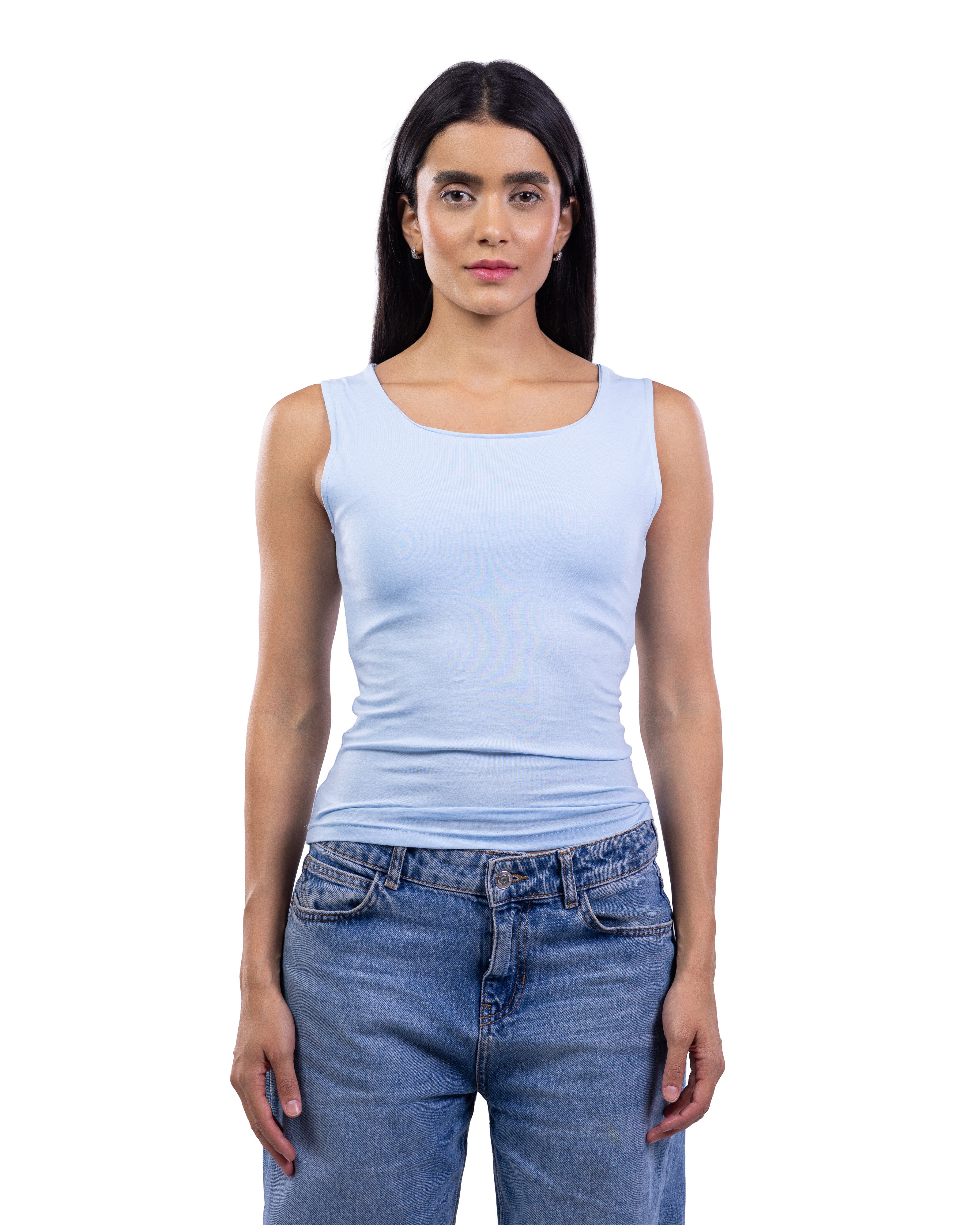 A woman modeling a light blue scoop-neck tank top paired with blue jeans, shot against a solid white background.