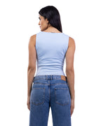 A woman shown from the back wearing a light blue sleeveless top and blue jeans against a plain white background.