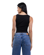 A woman shown from the back wearing a fitted black sleeveless top and blue jeans against a plain white studio background.