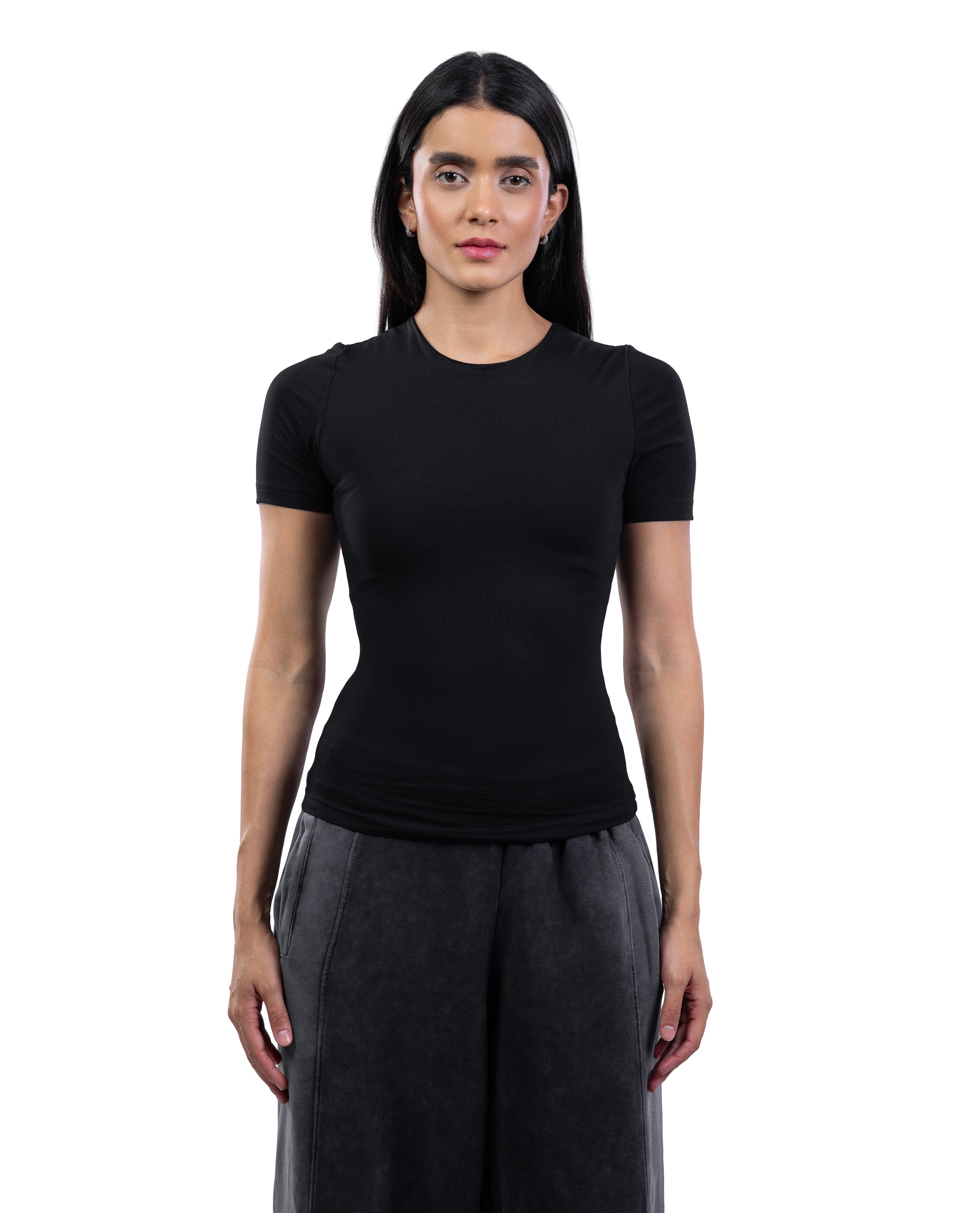 A woman modeling a fitted black short-sleeve crewneck top with dark gray wide-leg pants, standing against a plain white background.