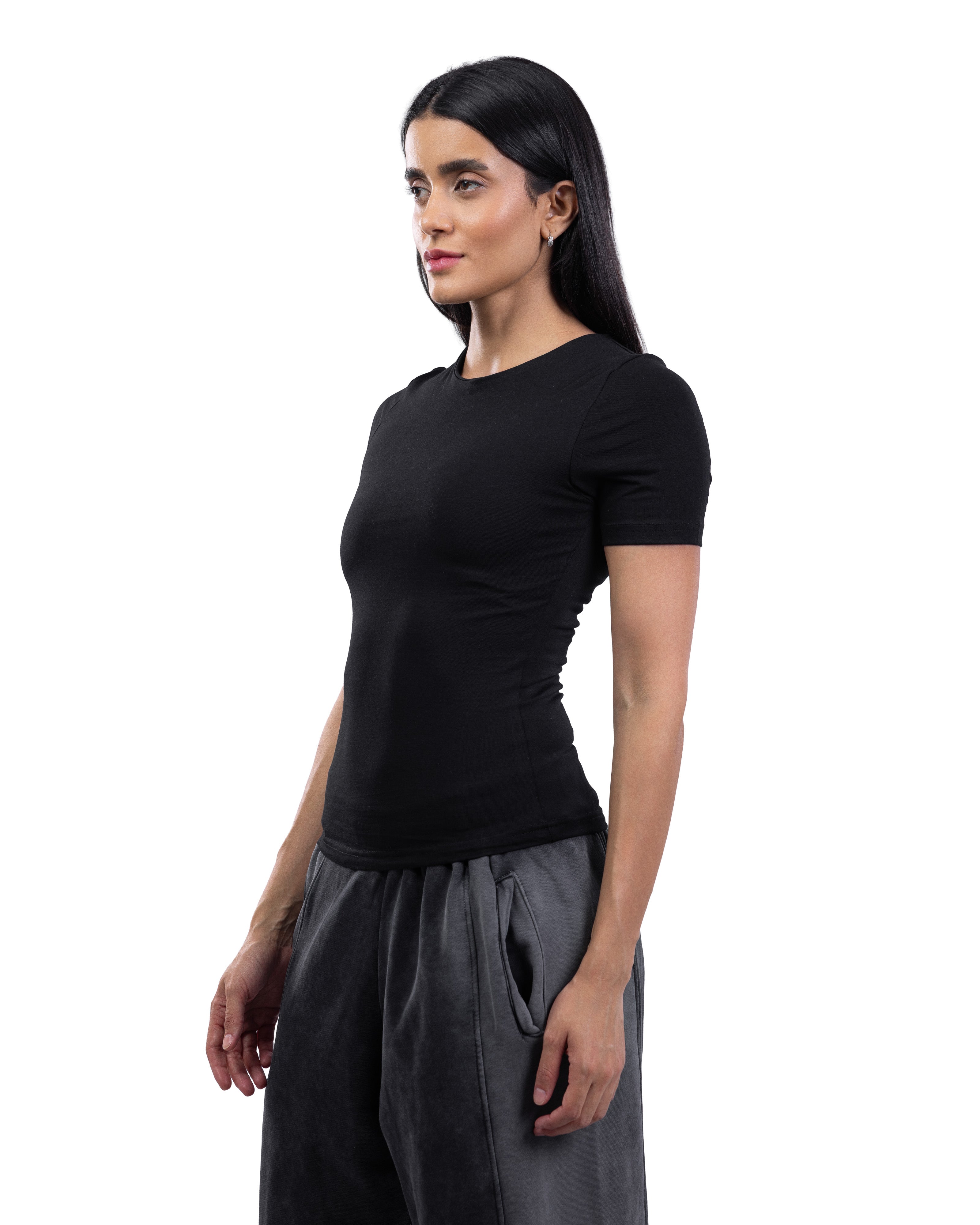 A woman modeling a fitted black short-sleeve crewneck top paired with dark gray wide-leg pants, photographed against a solid white background.