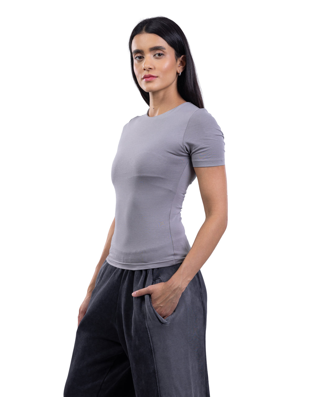 A woman modeling a fitted short-sleeve crewneck top in light gray, paired with dark gray wide-leg pants, against a plain white background.