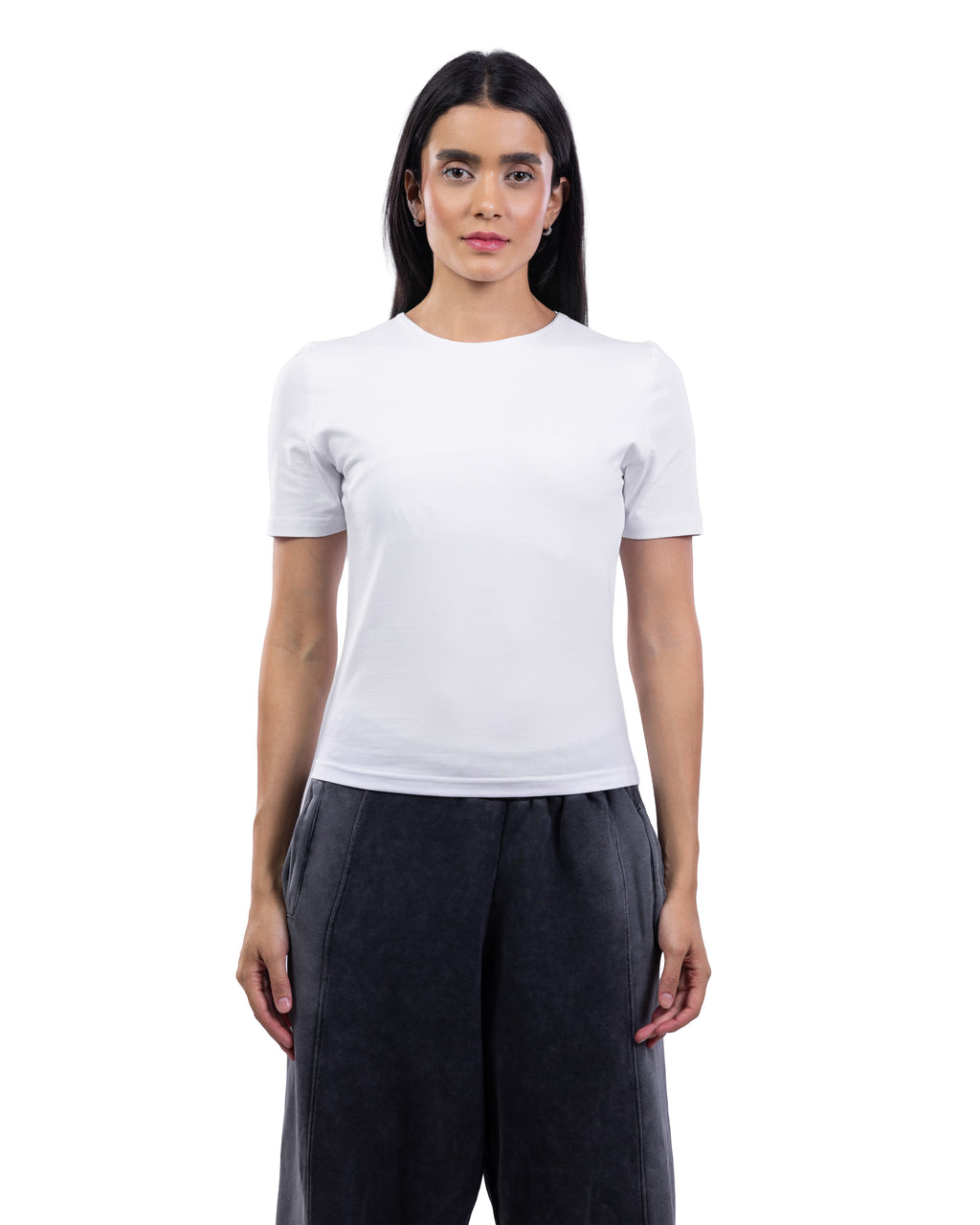A woman modeling a plain white short-sleeve crewneck t-shirt paired with dark charcoal gray wide-leg pants, shot against a seamless white background. [model:2]