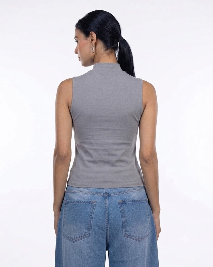 A woman shown from the back wearing a fitted sleeveless mock-neck top in heather gray and blue jeans, photographed against a plain white studio background.