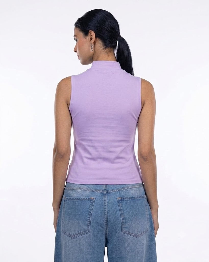 A woman shown from the back wearing a sleeveless lavender mock neck top and blue jeans against a plain white background.