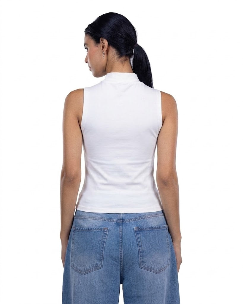 A woman shown from the back wearing a white sleeveless mock-neck top and blue jeans against a plain white background.