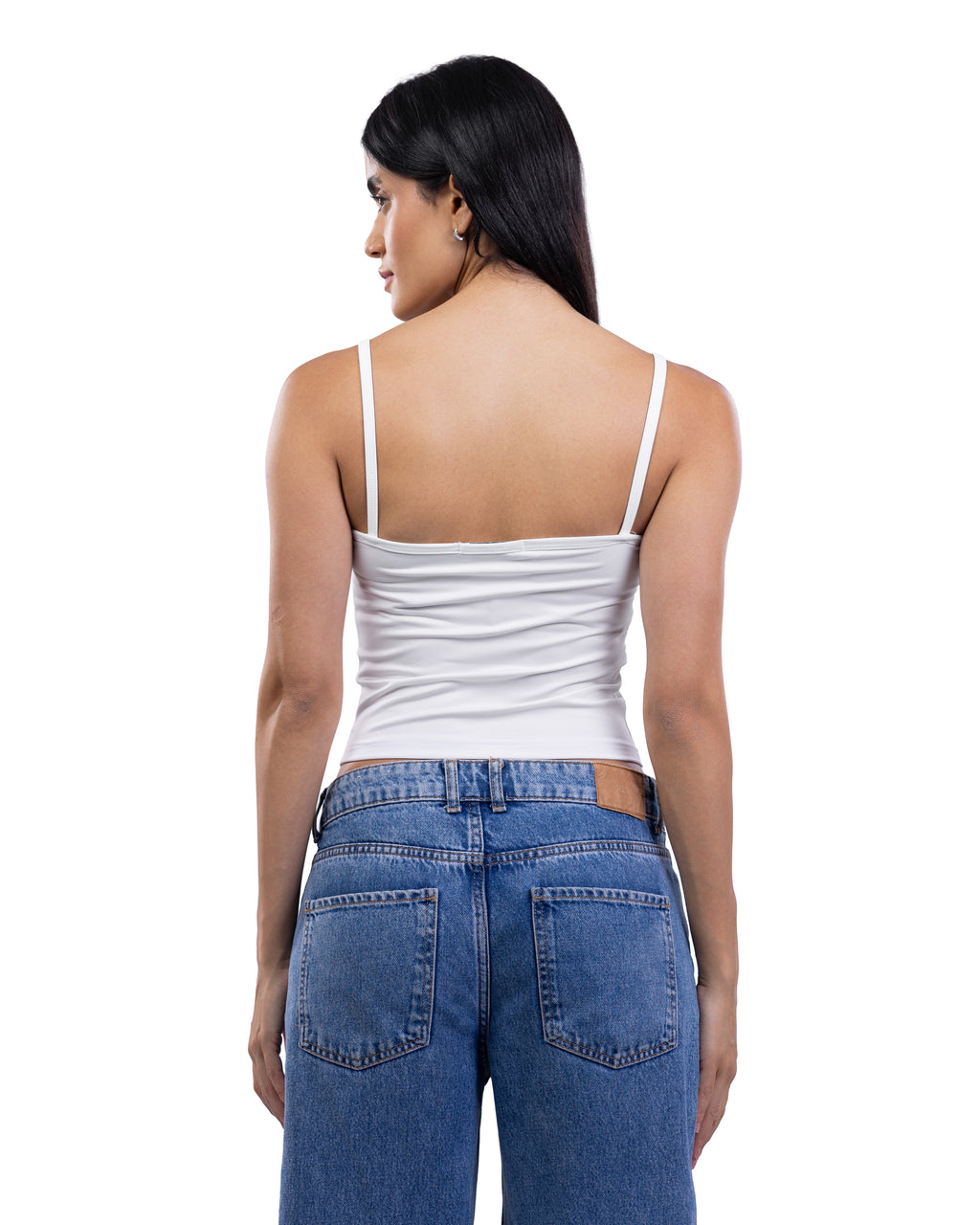 A woman shown from the back wearing a white spaghetti-strap camisole top and blue jeans against a plain white background.