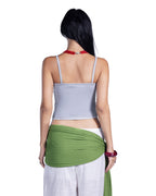 A woman shown from the back wearing a light gray spaghetti-strap crop top, white pants, and a green fabric wrap, against a plain white background.