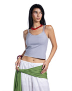 A woman modeling a light gray ribbed crop top with white pants and a green wrap, set against a plain white background.