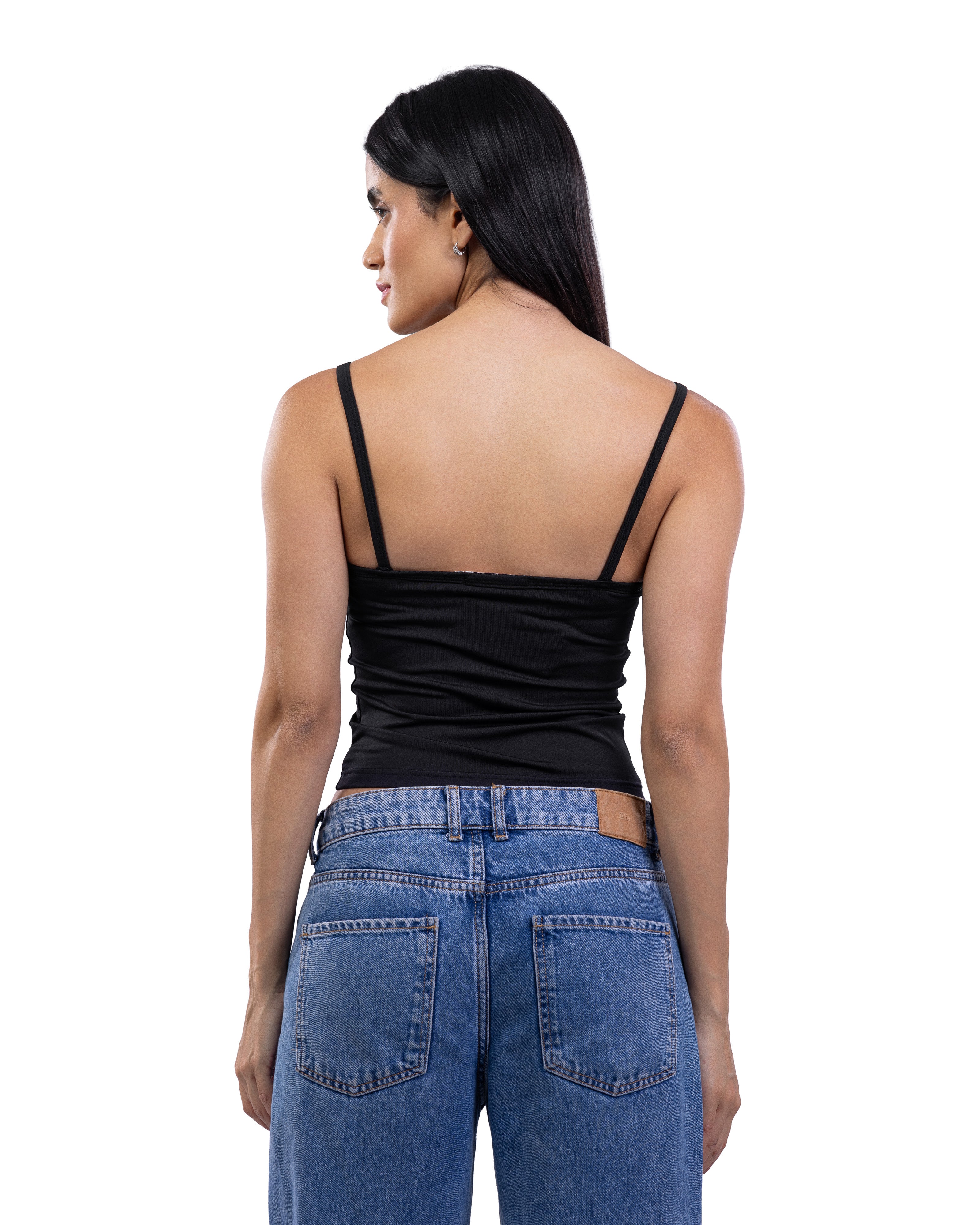 A woman shown from the back wearing a black spaghetti-strap camisole top and blue jeans against a plain white background.