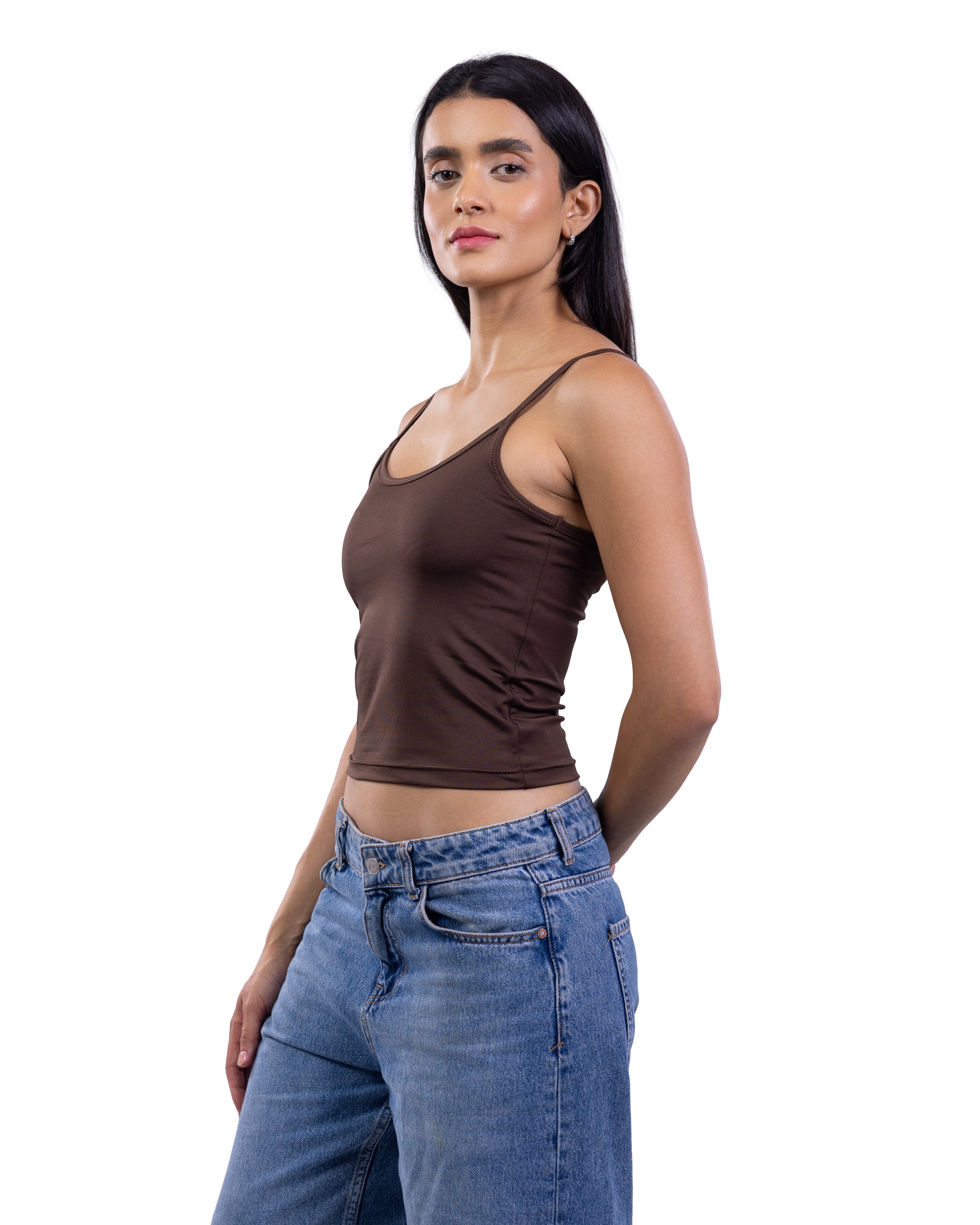 A woman modeling a fitted brown ribbed tank top paired with blue jeans, photographed against a plain white background.