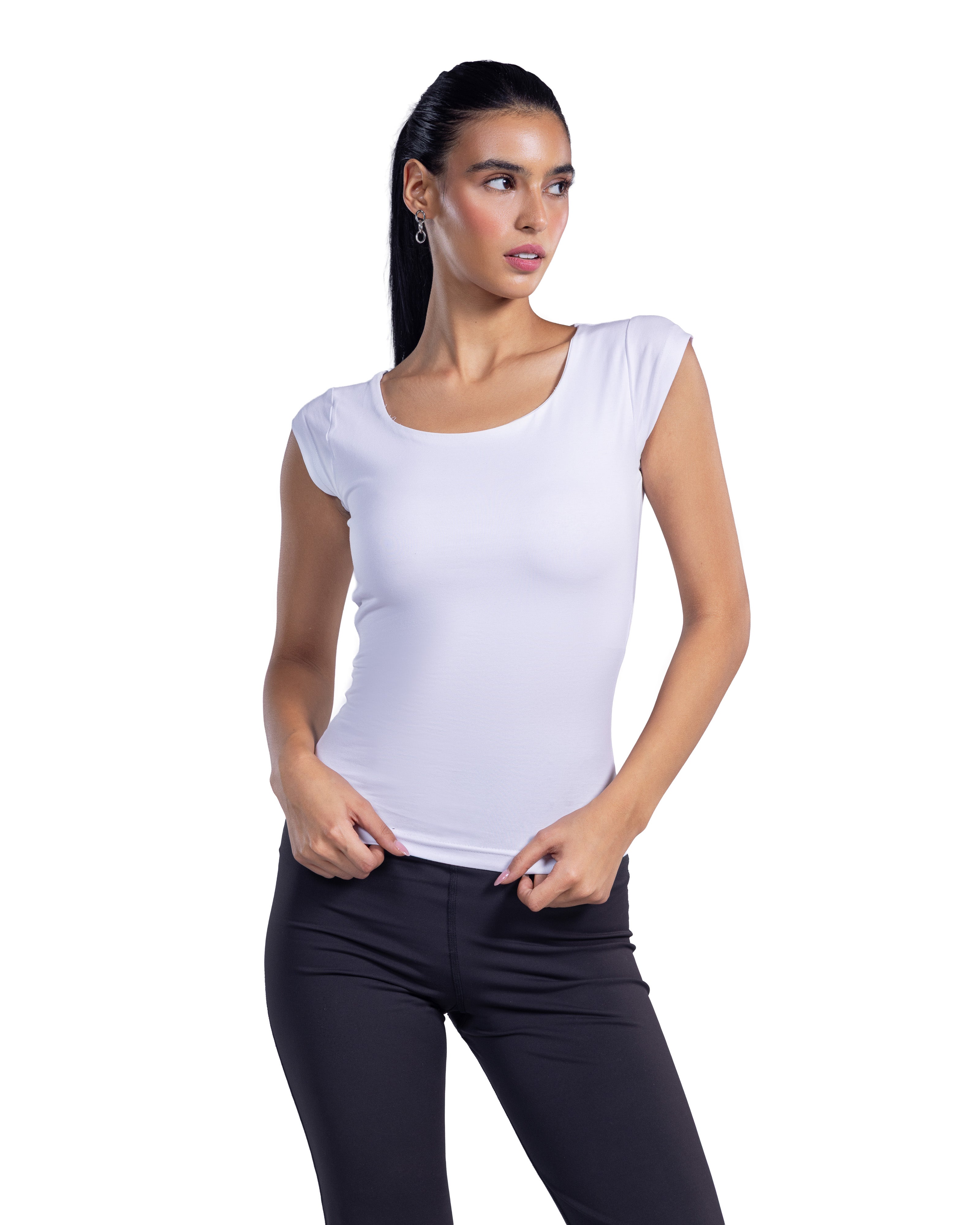 A woman modeling a white scoop-neck sleeveless top with cap sleeves, paired with black pants, against a plain white background.