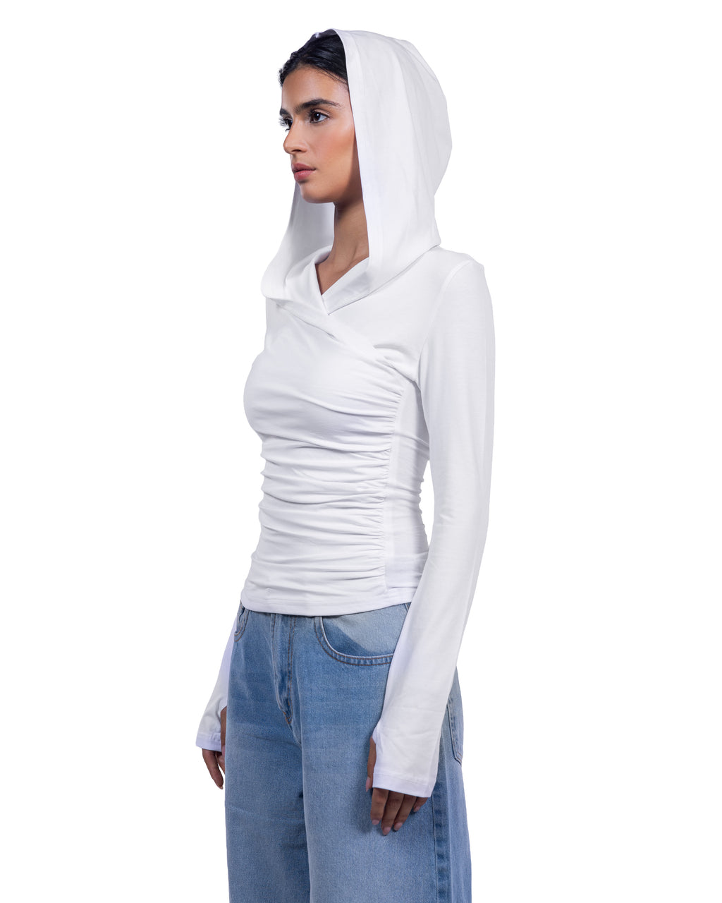 A woman wearing a fitted white long-sleeve hooded top with ruching at the chest, paired with light blue jeans, shown against a plain white background.