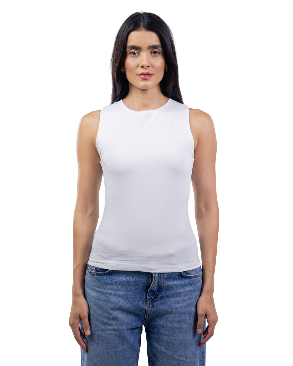A woman modeling a white sleeveless crew-neck tank top paired with blue jeans, shot against a solid white background.